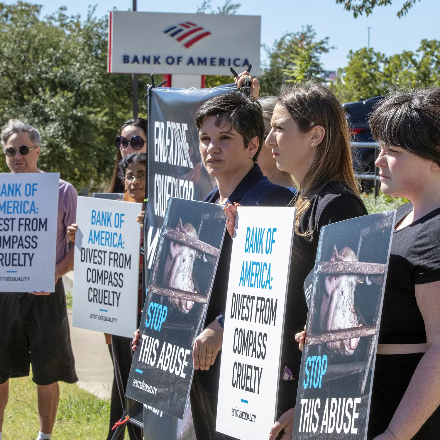 Activists holding posters and protesting against Bank of America, client of Compass Group